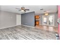 Living room with grey walls, wood-look floors and a view into the kitchen at 5724 Se 2Nd St, Ocala, FL 34480