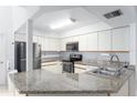 Galley-style kitchen with stainless steel appliances and granite countertops at 104 Coventry Ln, Haines City, FL 33844