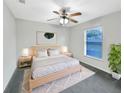 Bright bedroom with queen bed, wood nightstands, and ceiling fan at 1655 Ridgemoor Dr, Mascotte, FL 34753