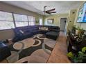 Spacious living room featuring a large sectional sofa and tile flooring at 206 Cooke St, Leesburg, FL 34748