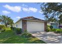 Single car garage with light beige door and brick facade at 24946 Cranes Roost Circle, Leesburg, FL 34748