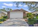 Two-car garage with light beige door and brick facade at 24946 Cranes Roost Circle, Leesburg, FL 34748