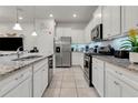 Modern kitchen featuring white cabinets, granite counters, and stainless steel appliances at 7424 Oakmoss Loop, Davenport, FL 33837