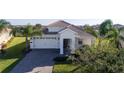 One story house with tile roof and a two car garage at 8990 Ace Loop, Davenport, FL 33896