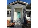 Modern home with a teal front door and gray brick archway at 911 Pine Ave, Mount Dora, FL 32757