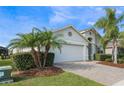 A one-story house with a white exterior, palm trees, and a brick driveway at 1012 Sadie Ridge Rd, Clermont, FL 34715