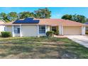 One-story house with solar panels and a landscaped yard at 117 Red Rose Cir, Orlando, FL 32835