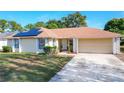 One-story house with solar panels and a landscaped yard at 117 Red Rose Cir, Orlando, FL 32835