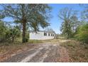 Side view of a white manufactured home on a wooded lot at 1210 Sr-33, Clermont, FL 34714