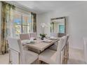 Elegant dining room featuring a large table, neutral decor, and natural light at 437 Caraway Dr, Kissimmee, FL 34759