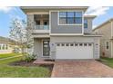 Two-story modern home with gray siding, brick accents, and a two-car garage at 2221 Avian Loop, Kissimmee, FL 34741