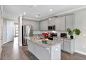 Modern kitchen with gray cabinets, granite countertops, and stainless steel appliances at 2221 Avian Loop, Kissimmee, FL 34741