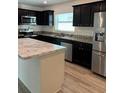 Modern kitchen with dark cabinets, granite countertops, and stainless steel appliances at 4633 Glencrest Loop, St Cloud, FL 34772
