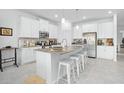 Modern kitchen with white cabinets, large island, and stainless steel appliances at 6115 Claystone Way, Mount Dora, FL 32757