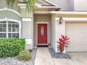 Red front door entry with landscaping and walkway at 2510 Black Lake Blvd, Winter Garden, FL 34787
