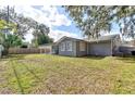 Renovated home showcasing a spacious backyard with mature trees and a wooden fence at 58 Pine Trl, Ormond Beach, FL 32174