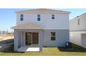 Two-story home's back features a covered patio and grassy yard at 6805 Serpent Hawk Lane St, Howey In The Hills, FL 34737