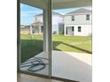 View of backyard from sliding glass doors, showing grass and neighboring homes at 6858 Spanish Imperial St, Howey In The Hills, FL 34737