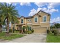Two-story house with tan exterior, palm trees, and a three-car garage at 1827 Pisgah Ln, Apopka, FL 32712