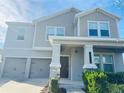 Two-story house with gray siding, stone accents, and a two-car garage at 10118 Storey Grove Way, Winter Garden, FL 34787