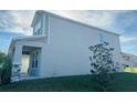 Side view of two-story house, gray siding, and covered porch at 10118 Storey Grove Way, Winter Garden, FL 34787
