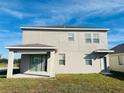 Rear view of two-story house with covered patio at 10118 Storey Grove Way, Winter Garden, FL 34787