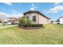 Side view of a tan house with a palm tree and lush landscaping at 11637 Meadow Grove Cir, Orlando, FL 32836