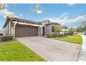 House exterior featuring a brick paver driveway and pergola at 11637 Meadow Grove Cir, Orlando, FL 32836