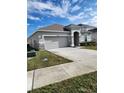 Single-story home with a two-car garage and landscaping at 3509 Yarian Dr, Haines City, FL 33844