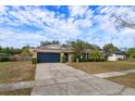 One-story house featuring a stone exterior, dark garage door, and neat landscaping at 6928 Sugarbush Dr, Orlando, FL 32819