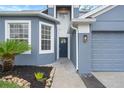 Front entrance with a dark blue door and landscaping at 2806 Balforn Tower Way, Winter Garden, FL 34787