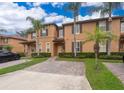 Tan two-story townhome with palm trees and brick driveway at 3030 Calabria Ave # 436, Davenport, FL 33897