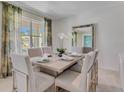 Elegant dining room featuring a large table, artwork, and natural light at 3535 Sandalwood Isle Way, Ocoee, FL 34761