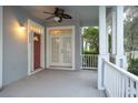 Covered porch with white railings, a red door, and a ceiling fan at 3809 Sun Dew Dr, Orlando, FL 32828