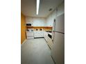 Galley kitchen with white cabinets and orange walls at 4136 Versailles Dr # 4136D, Orlando, FL 32808