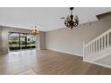 Spacious living room featuring hardwood floors, a view of the backyard, and a chandelier at 6292 Twain St # 101, Orlando, FL 32835