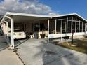 Mobile home with carport, screened porch, and paved driveway at 310 Polo Park East Blvd, Davenport, FL 33897