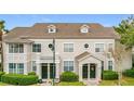 Two-story townhome with neutral exterior, two front doors, and landscaping at 5269 Wellington Park Cir # 23, Orlando, FL 32839