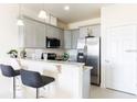 Modern kitchen with granite countertops, stainless steel appliances, and breakfast bar at 1784 Coriander Dr, Kissimmee, FL 34759