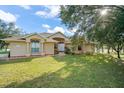 Tan house with large windows and a well-manicured lawn at 1855 S Lehigh Dr, Deltona, FL 32738