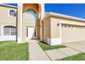 Front entrance of a two-story house with a white door and arched window at 415 Big Sioux Ct, Kissimmee, FL 34759