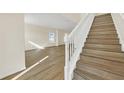 Wooden staircase with white railing leading to the upper level at 415 Big Sioux Ct, Kissimmee, FL 34759