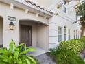 Inviting entryway with a dark brown door and lush greenery at 4775 Terrasonesta Dr, Davenport, FL 33837