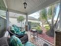 Relaxing screened porch with wicker seating and a view of the yard at 25001 Cranes Roost Cir, Leesburg, FL 34748
