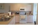 Cozy kitchen featuring white appliances and ample cabinet space at 259 Grand Rapids Dr, Poinciana, FL 34759