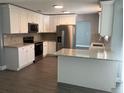 Modern kitchen featuring white cabinets, granite counters, and stainless steel appliances at 5241 Magnolia Ter, Fruitland Park, FL 34731
