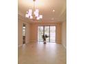 Spacious dining room with sliding glass doors and chandelier at 573 Lago Matisse St, Kissimmee, FL 34759