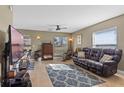 Spacious living room with leather reclining sofa and large TV at 20106 Sunset Landing Ave, Groveland, FL 34736