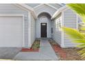 Dark-colored front door with a walkway and landscaping at 2080 Cobblefield Cir, Apopka, FL 32703