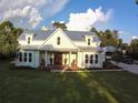 White farmhouse with metal roof, large yard, and driveway at 2293 Eldorado Ct, St Cloud, FL 34771